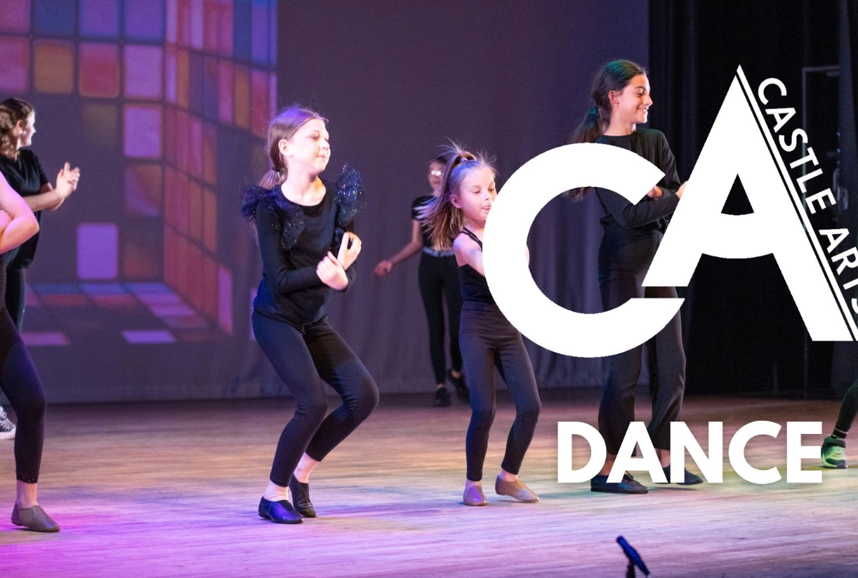 children dressed in black dancing on stage