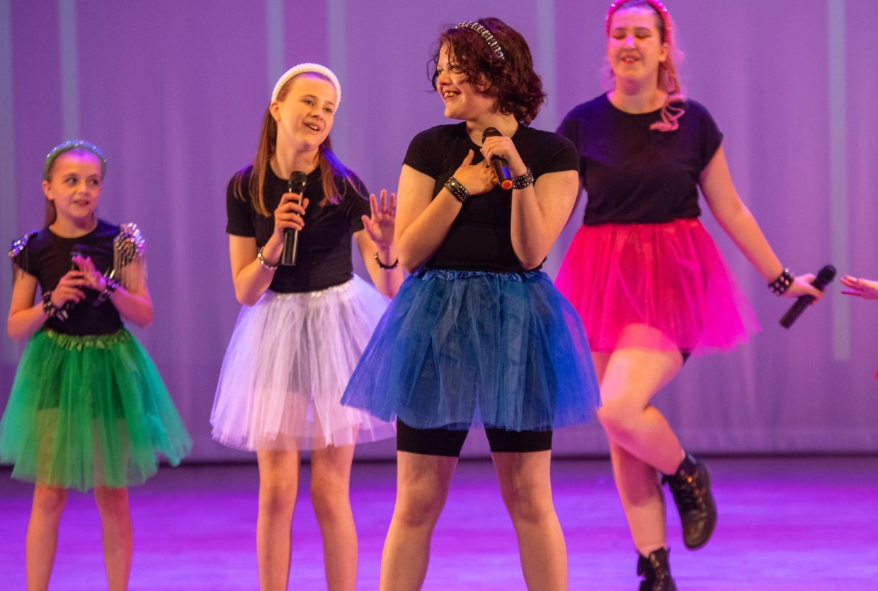 girls in colourful tutus singing