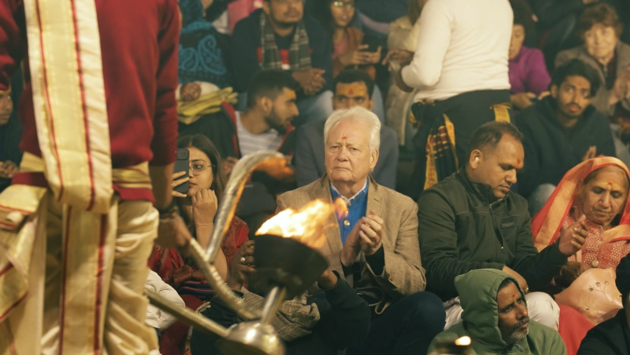 white man sat amongth indian people with religious ceremony taking place