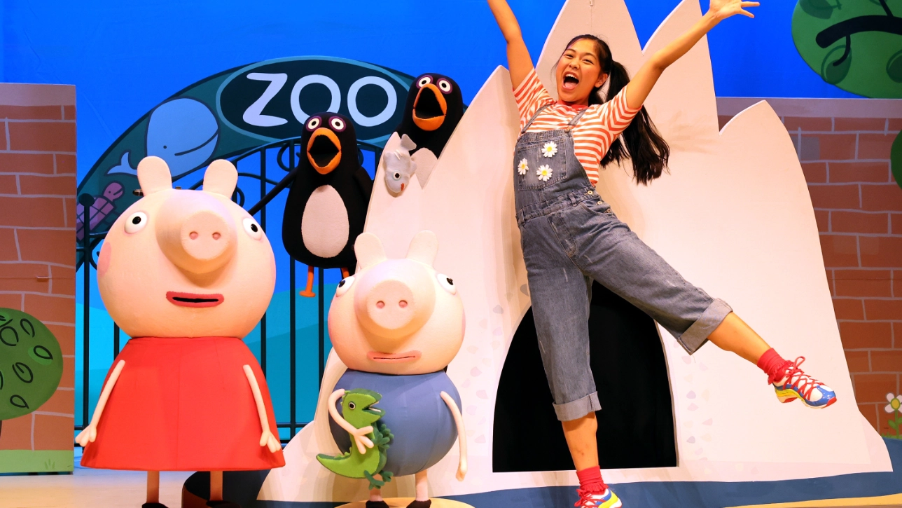 Image of Peppa Pig, Penguin and a lady waving on stage