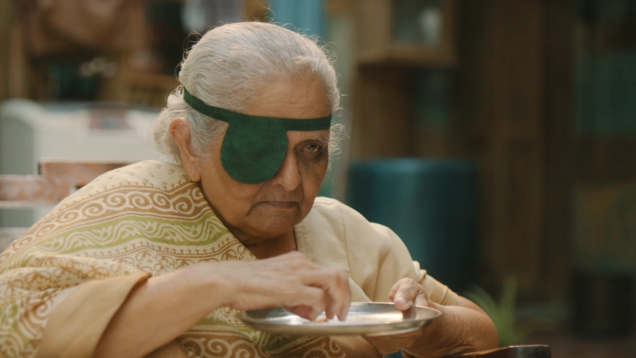 Older Indian women with eye patch eating