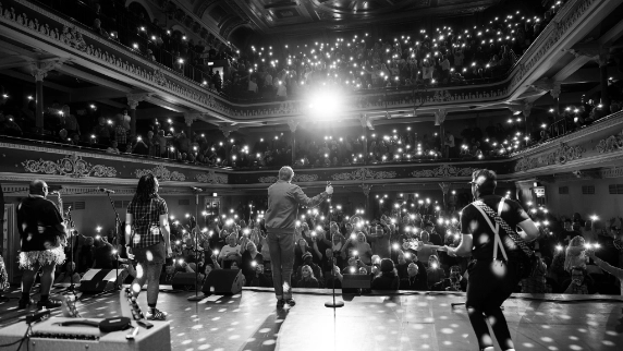 Black-and-white photo of Too Much Too Young live concert from the stage perspective